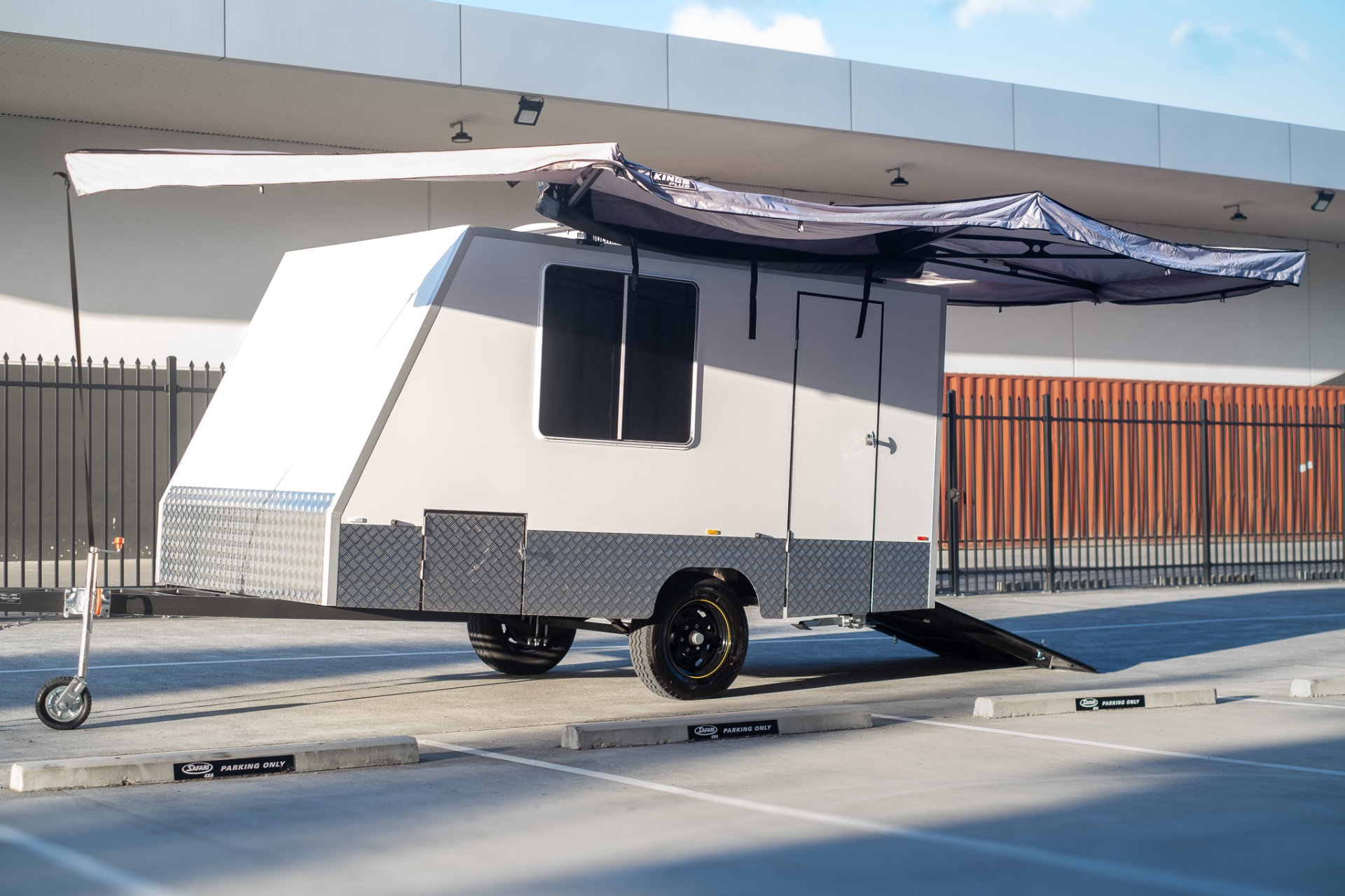 MotoCampers 001 enclosed trailer with side door, awning and rear loading ramp